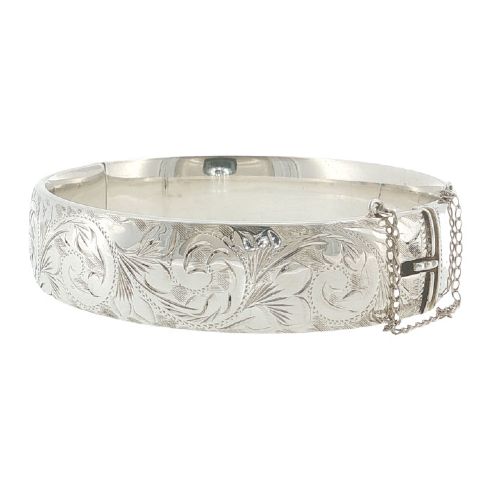 fig 1. A sterling silver hinged bangle featuring floral hand engraving around the exterior band and an attached safety chain.