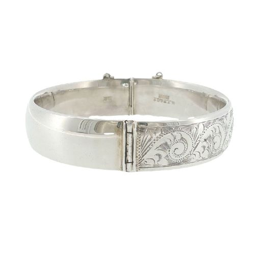 fig 2. A sterling silver hinged bangle featuring floral hand engraving around the exterior band and an attached safety chain.