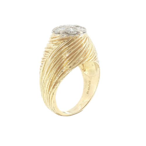 fig 5. A vintage 18ct yellow gold ring featuring a central round cluster of seven diamonds surrounded by a wide, textured gold border.