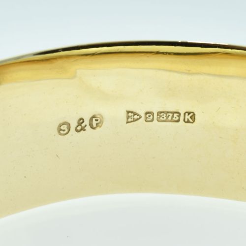 fig 2. A wide 9ct yellow gold hinged bangle featuring star-set round rubies along a textured band.
