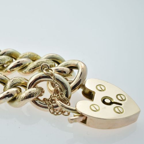 An antique 9ct gold curb link bracelet featuring half-engraved links, a heart-shaped padlock clasp, and an attached safety chain. View II