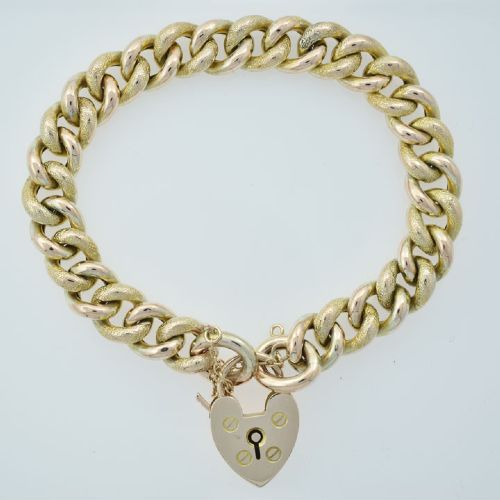 An antique 9ct gold curb link bracelet featuring half-engraved links, a heart-shaped padlock clasp, and an attached safety chain. View IV