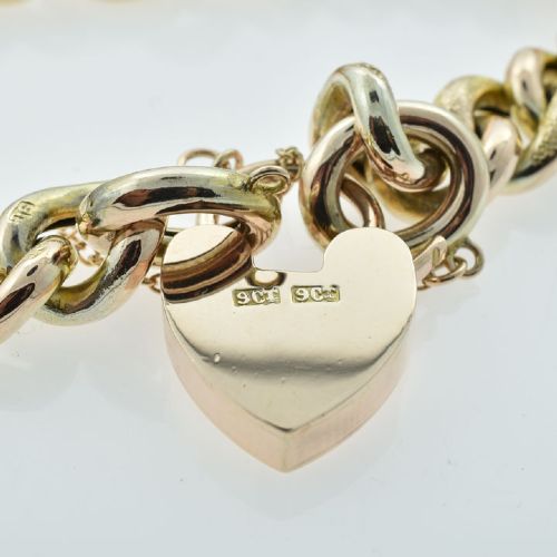 An antique 9ct gold curb link bracelet featuring half-engraved links, a heart-shaped padlock clasp, and an attached safety chain. View VIII
