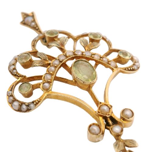 An openwork 15ct yellow gold Edwardian pendant set with small seed pearls and light green peridot gemstones with a central oval stone and hanging drop. View III