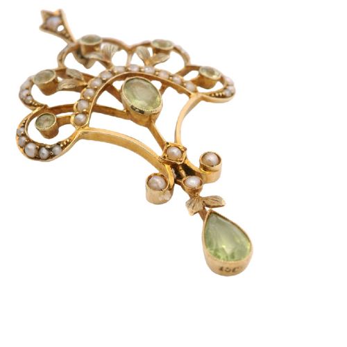 An openwork 15ct yellow gold Edwardian pendant set with small seed pearls and light green peridot gemstones with a central oval stone and hanging drop. View IV