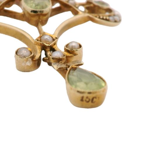 An openwork 15ct yellow gold Edwardian pendant set with small seed pearls and light green peridot gemstones with a central oval stone and hanging drop. View V