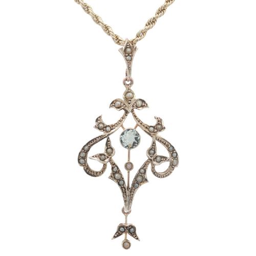 fig 1. An openwork 9ct yellow gold Edwardian pendant set with a central round aquamarine and embellished with small seed pearls throughout.