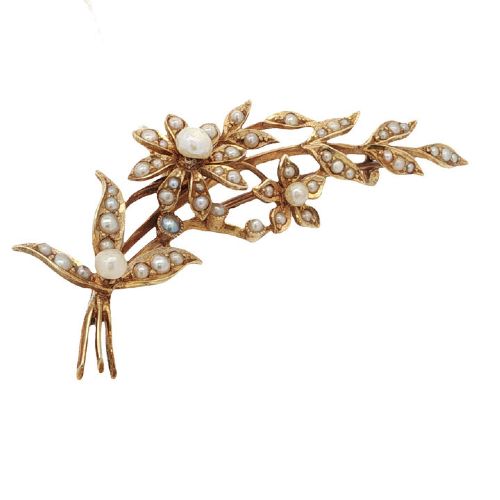 fig 1. An antique 15ct yellow gold floral spray brooch featuring articulated flowers and leaves set with seed pearls, attached to a safety chain.
