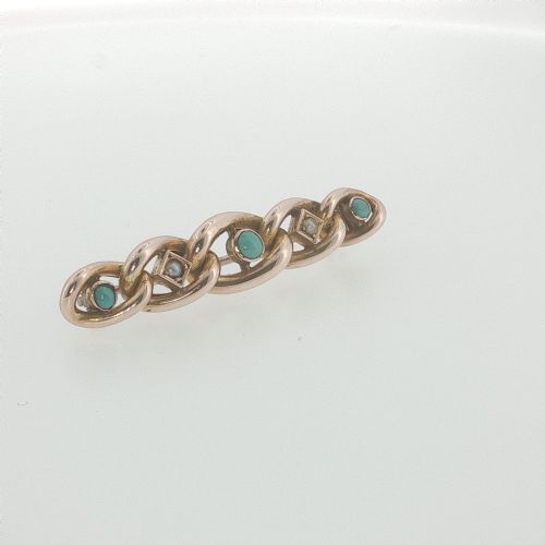 fig 2. An antique 9ct rose gold bar brooch with curb links set with turquoise cabochons and seed pearls resting in a fitted presentation box.