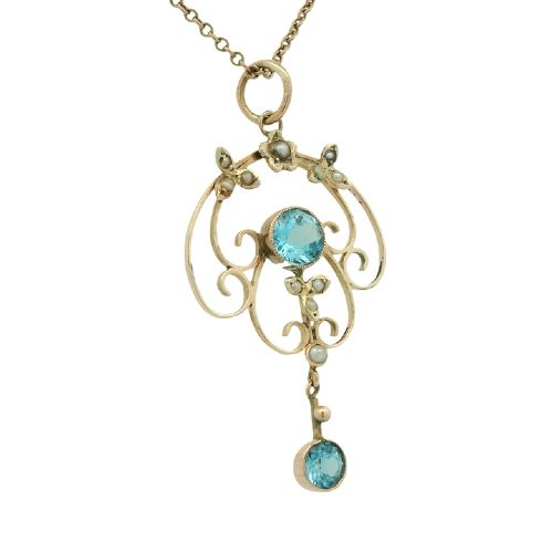 An antique 9ct yellow gold openwork pendant featuring two round blue topaz stones and seed pearl accents suspended on a fine chain. View II