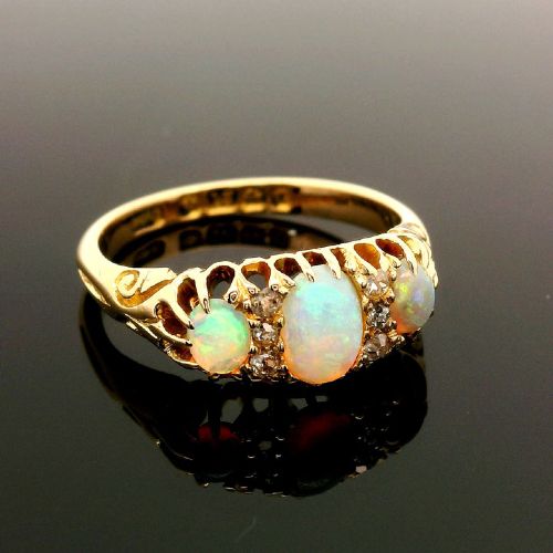 fig 1. An 18ct yellow gold Edwardian boat ring set with three oval cabochon opals and small diamond accents within a carved gallery.