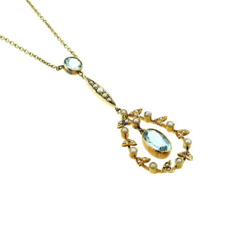 fig 2. An Edwardian 15ct gold lavalier necklace featuring a round aquamarine top stone, a seed-pearl-set vertical bar, and a floral garland pendant surrounding a suspended oval aquamarine.