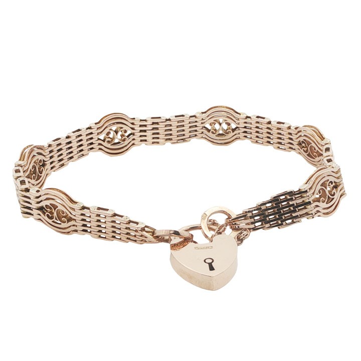 An antique 9ct rose gold gate link bracelet featuring openwork scroll panels, a heart padlock clasp, and a safety chain.