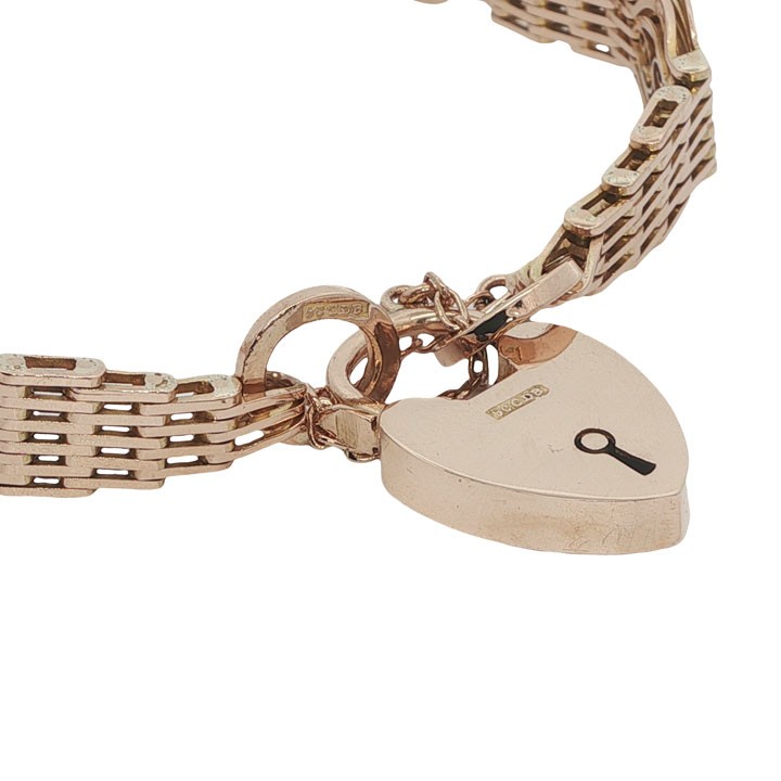 An antique 9ct rose gold gate link bracelet featuring openwork scroll panels, a heart padlock clasp, and a safety chain. View V