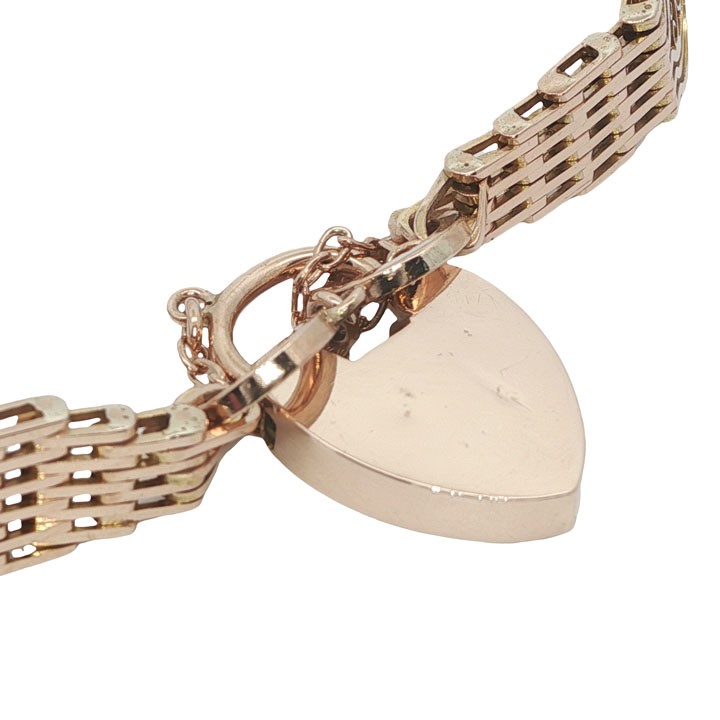 An antique 9ct rose gold gate link bracelet featuring openwork scroll panels, a heart padlock clasp, and a safety chain. View VII