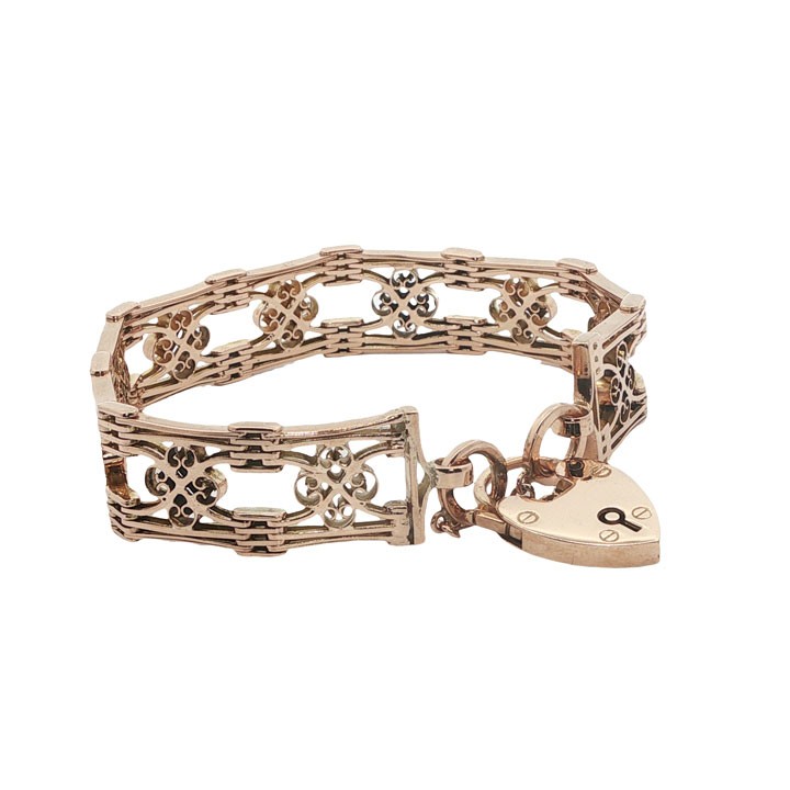 An antique 9ct rose gold gate link bracelet featuring decorative openwork filigree panels and a heart-shaped padlock clasp. View IV