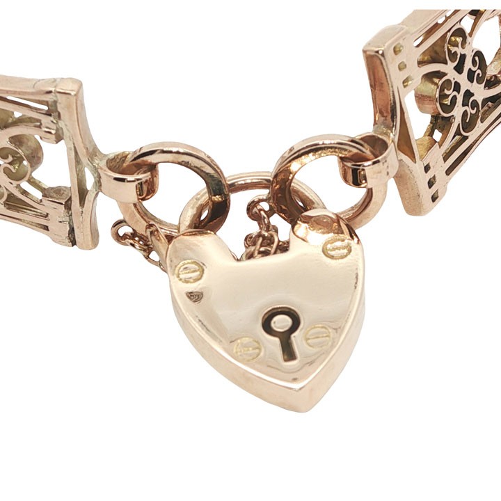 An antique 9ct rose gold gate link bracelet featuring decorative openwork filigree panels and a heart-shaped padlock clasp. View V