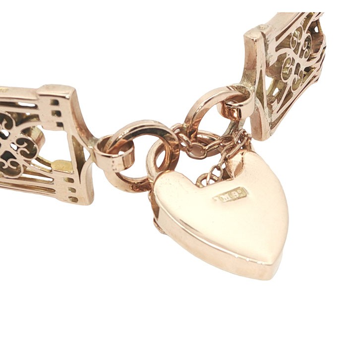An antique 9ct rose gold gate link bracelet featuring decorative openwork filigree panels and a heart-shaped padlock clasp. View VI