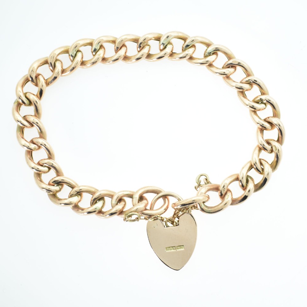 An antique rose gold curb link bracelet featuring alternating plain and engraved links fastened with a heart-shaped padlock clasp. View II