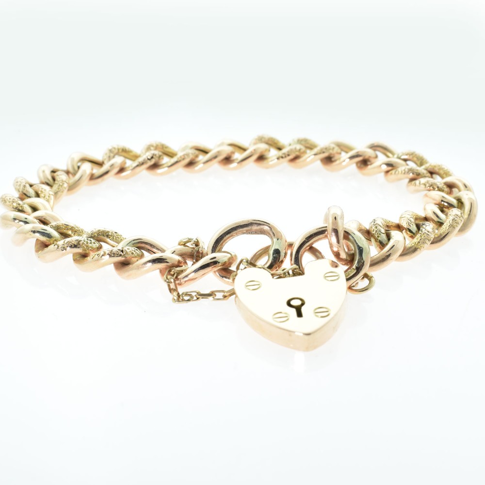 An antique rose gold curb link bracelet featuring alternating plain and engraved links fastened with a heart-shaped padlock clasp. View III