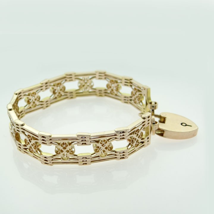 An antique 9ct rose gold fancy gate link bracelet featuring pierced scrollwork panels and a heart padlock clasp with a safety chain. View V