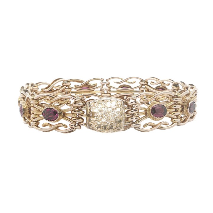 An antique 9ct rose gold link bracelet featuring oval-cut almandine garnets set in ornate scrollwork links with a box clasp. View V