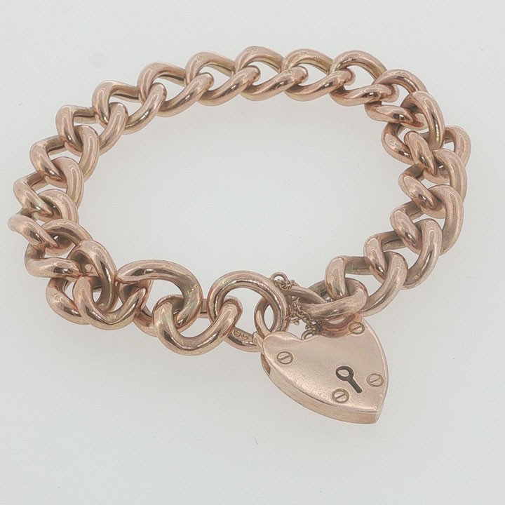 An Edwardian 9ct rose gold curb link bracelet featuring a heart-shaped padlock clasp and safety chain. View II