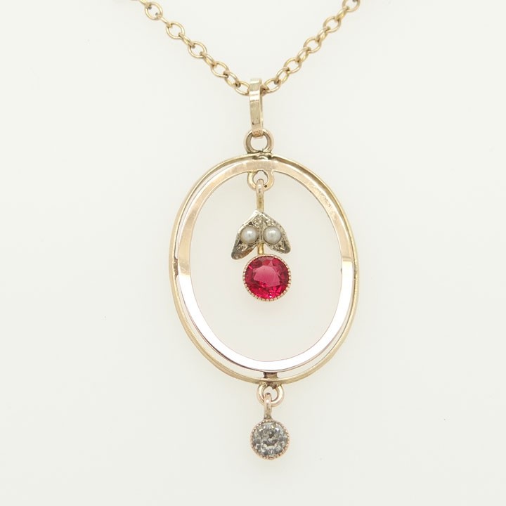 An open oval 9ct yellow gold pendant featuring an inner suspended drop set with two seed pearls and a pink paste stone, finished with an articulated clear paste drop below. View II