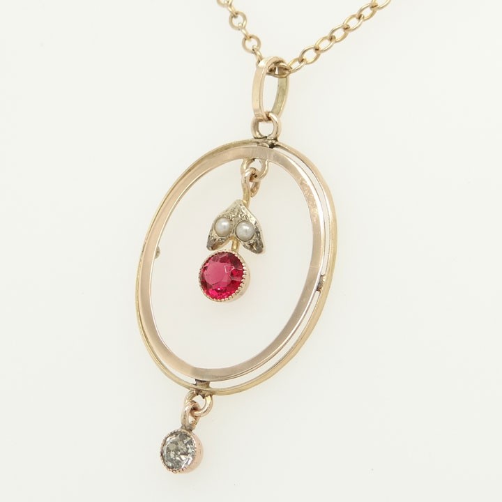 An open oval 9ct yellow gold pendant featuring an inner suspended drop set with two seed pearls and a pink paste stone, finished with an articulated clear paste drop below. View III