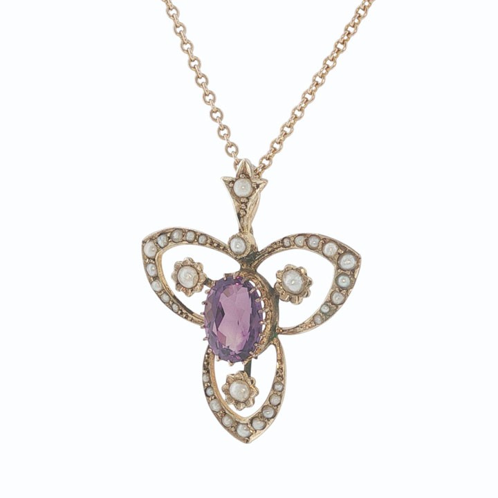 An Edwardian 9ct gold openwork pendant featuring a central oval amethyst surrounded by delicate seed pearls on a fine chain. View IV
