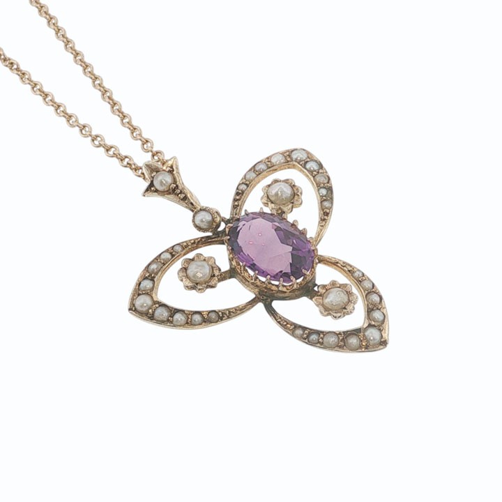 An Edwardian 9ct gold openwork pendant featuring a central oval amethyst surrounded by delicate seed pearls on a fine chain. View V