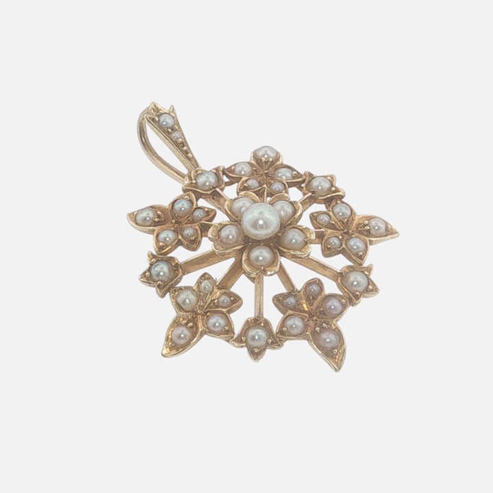 A late Victorian 15ct gold starburst pendant set with central and accent seed pearls forming a floral motif. View II