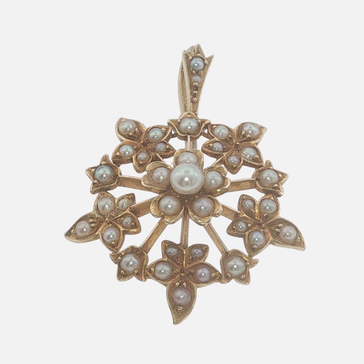 A late Victorian 15ct gold starburst pendant set with central and accent seed pearls forming a floral motif. View III