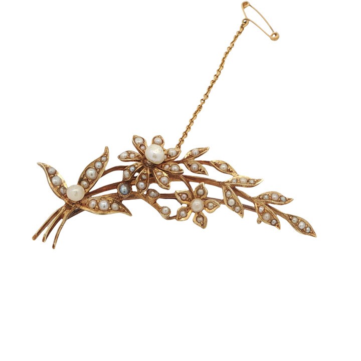 An antique 15ct yellow gold floral spray brooch featuring articulated flowers and leaves set with seed pearls, attached to a safety chain. View V