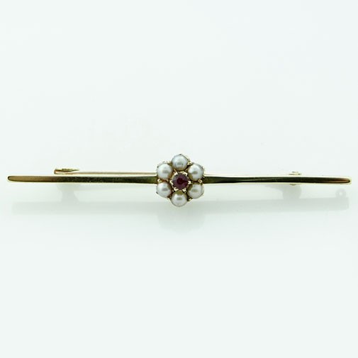 An antique yellow gold bar brooch featuring a central flower cluster set with a crimson almandine garnet and surrounding white seed pearls. View II