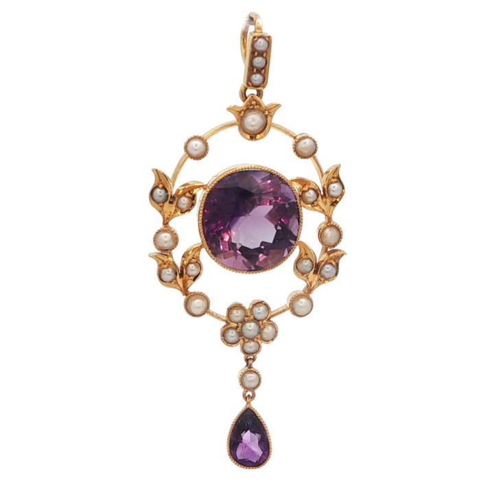An openwork 15ct yellow gold oval pendant featuring a central round faceted amethyst framed by seed pearl leaf motifs, with a pear-cut amethyst drop suspended below.
