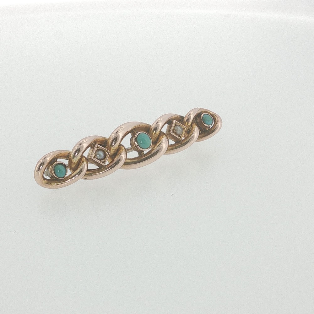 An antique 9ct rose gold bar brooch with curb links set with turquoise cabochons and seed pearls resting in a fitted presentation box. View III