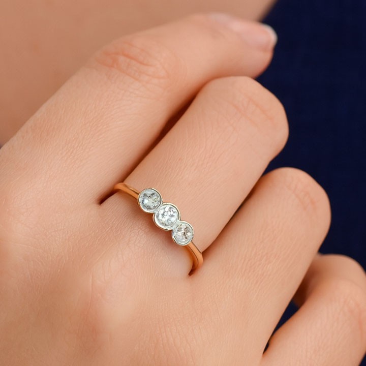 An antique 18ct yellow gold ring set with three round old-cut diamonds in a horizontal trilogy setting. View VII