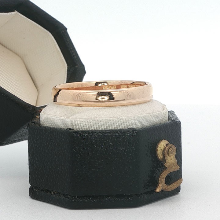 A plain 3mm 22ct yellow gold wedding band ring displaying visible internal hallmarks.