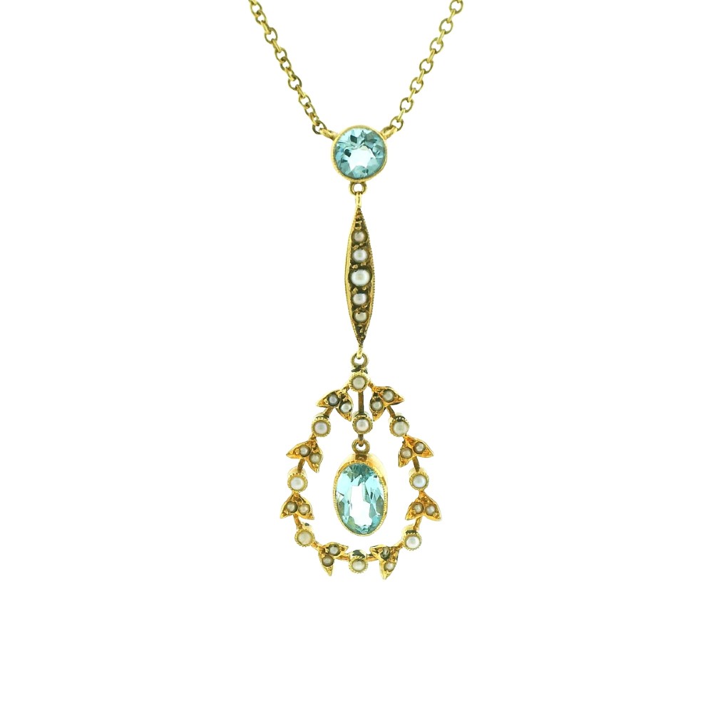 An Edwardian 15ct gold lavalier necklace featuring a round aquamarine top stone, a seed-pearl-set vertical bar, and a floral garland pendant surrounding a suspended oval aquamarine. View II