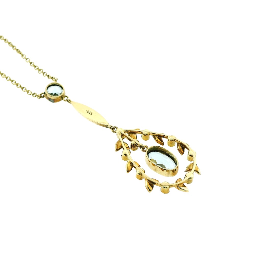An Edwardian 15ct gold lavalier necklace featuring a round aquamarine top stone, a seed-pearl-set vertical bar, and a floral garland pendant surrounding a suspended oval aquamarine. View IV