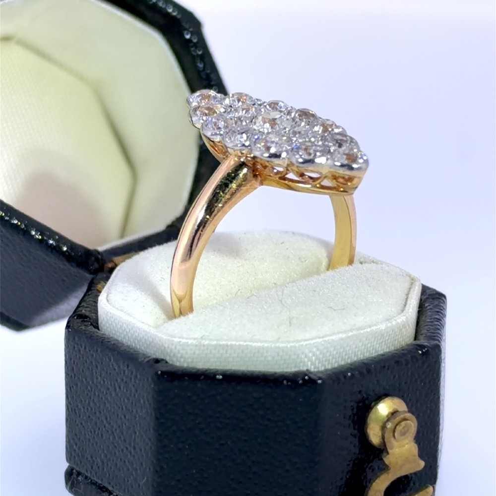 An Edwardian navette cluster ring featuring multiple old cut diamonds set in platinum with an 18ct yellow gold band. View III