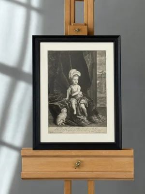 fig 1. A framed monochrome mezzotint portrait depicting a young child in formal historical drapery seated beside a small dog.