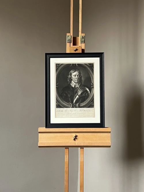 fig 5. A framed monochrome mezzotint portrait depicting Oliver Cromwell in armour set within a carved oval cartouche.