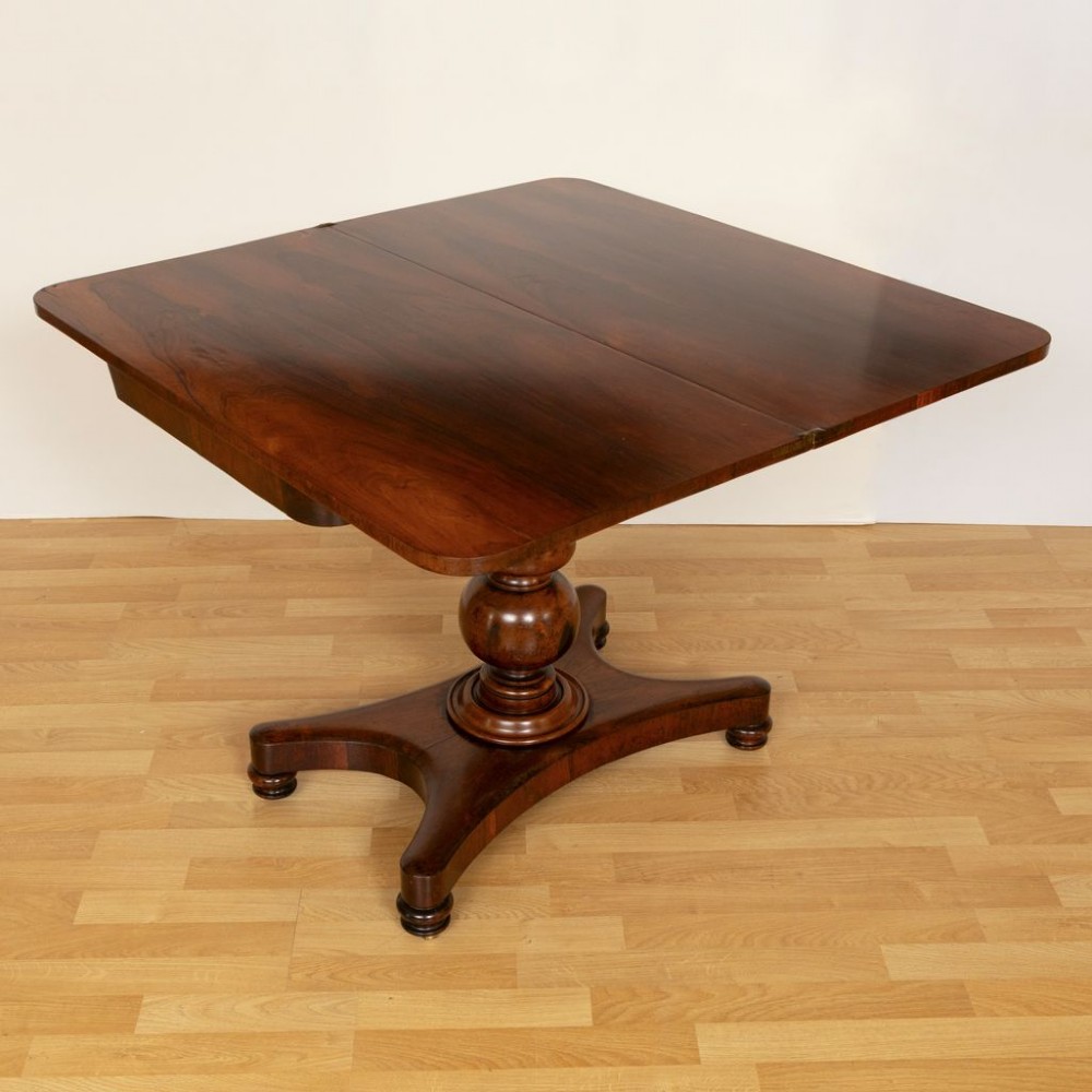 A Regency rosewood card table featuring a fold-over top, turned pedestal column, and quadripartite platform base on turned feet. View II