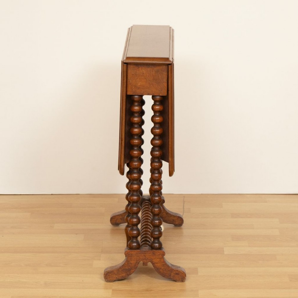 A Victorian walnut drop-leaf side table featuring distinct bobbin-turned legs, a stretcher base, and ceramic castors. View II