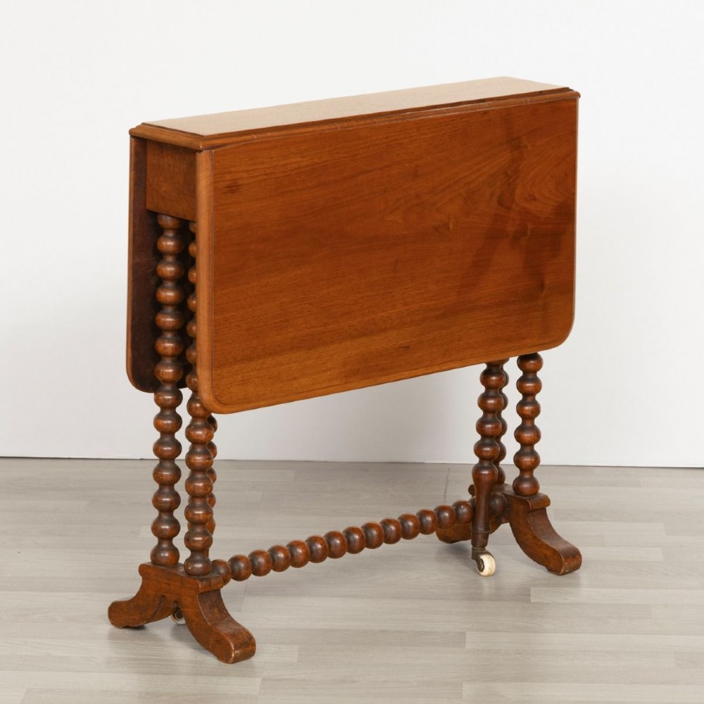 A Victorian walnut drop-leaf side table featuring distinct bobbin-turned legs, a stretcher base, and ceramic castors. View III