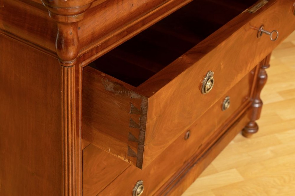 A 19th-century French walnut commode featuring four drawers, turned column side details, and brass keyhole escutcheons. View II