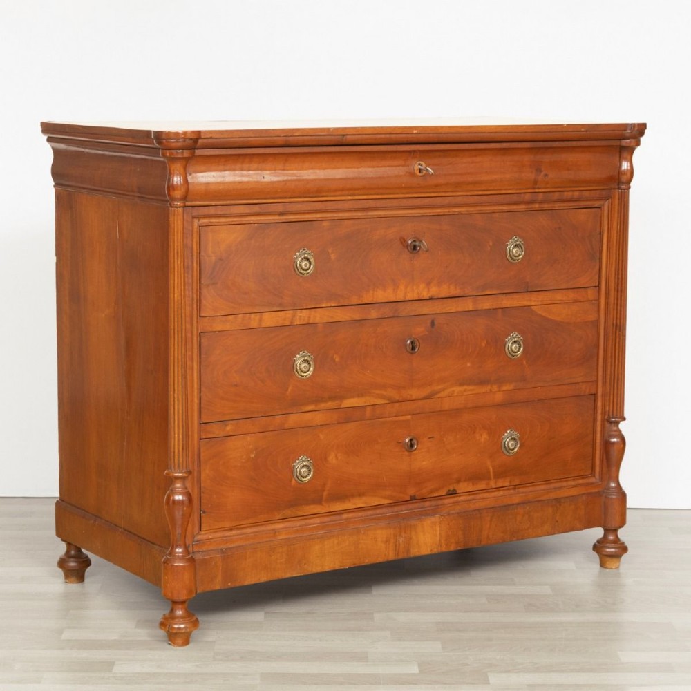 A 19th-century French walnut commode featuring four drawers, turned column side details, and brass keyhole escutcheons. View III