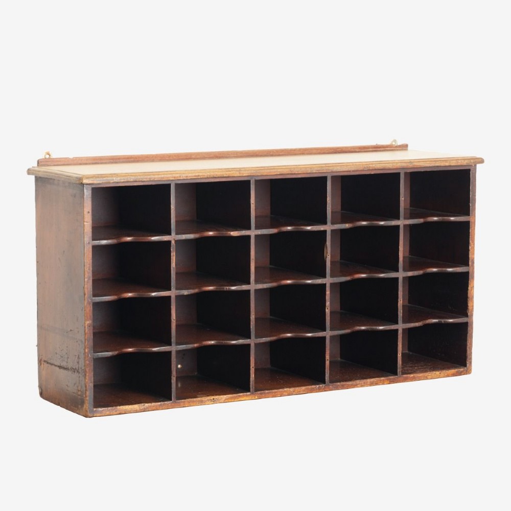 A 19th-century dark mahogany desktop pigeon hole unit featuring twenty-four open rectangular compartments with contoured shelf edges.
